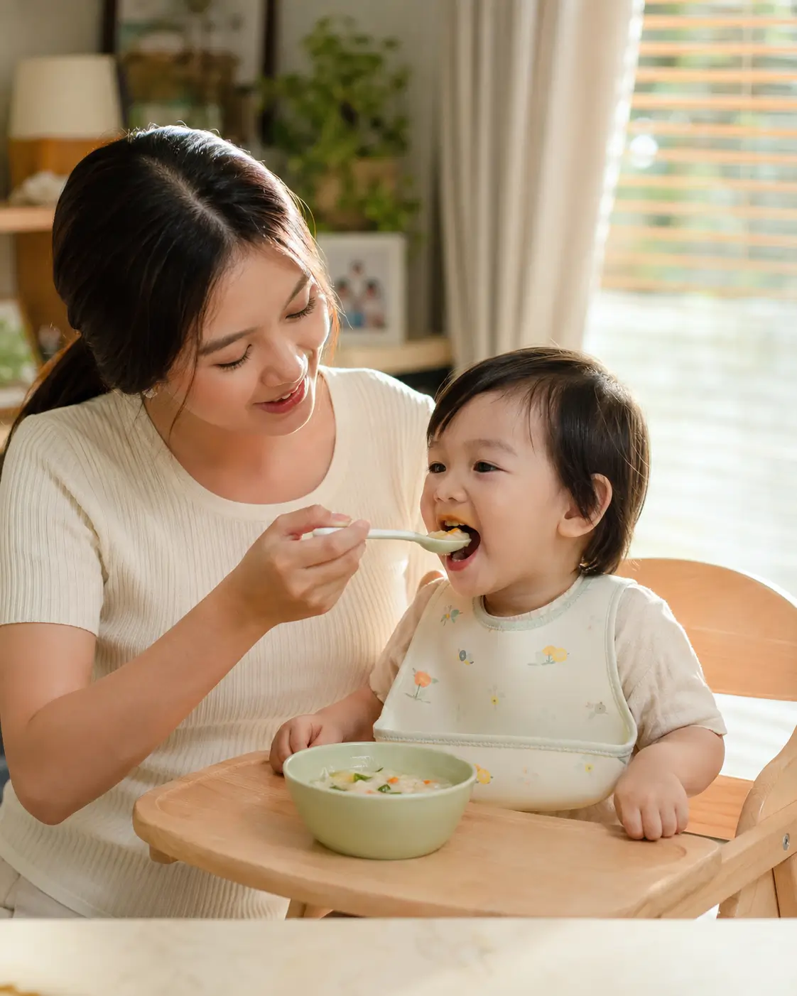 แม่ไทยกำลังช่วยลูกวัยเตาะแตะค่อย ๆ กลับมากินอาหารทีละคำที่บ้าน